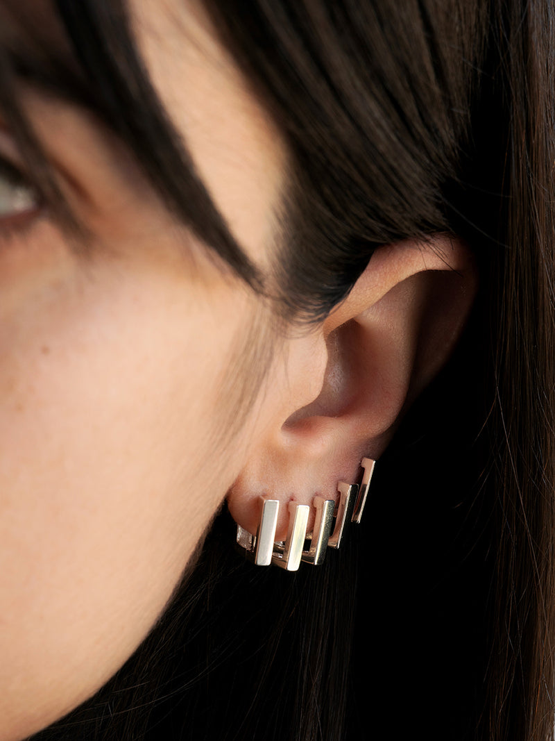 Argollas Regi de plata 925 con diseño cuadrado de 12 mm de diámetro y 3 mm de frente, un estilo geométrico y moderno sobre fondo blanco sobre oreja.